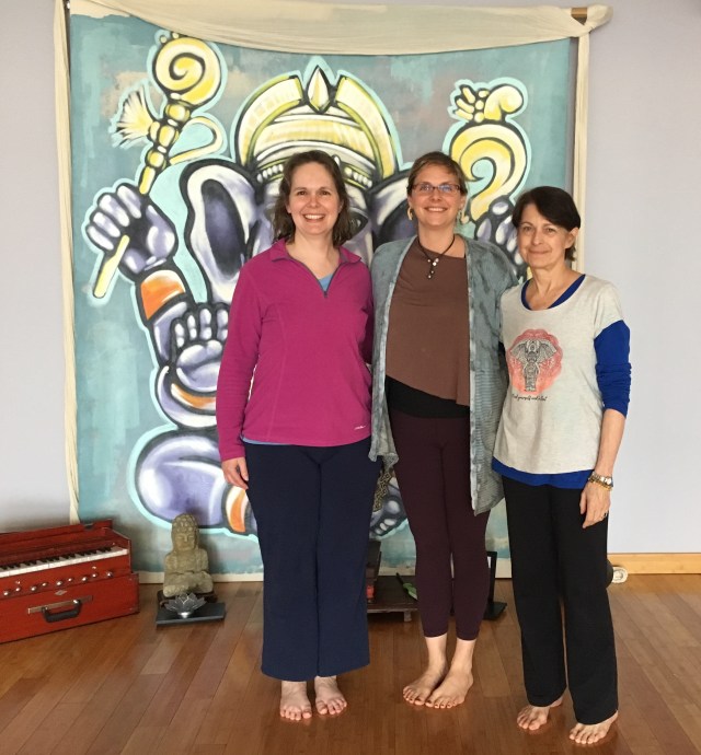 Photograph of three teachers in front of Ganesh banner at Sanctuary.